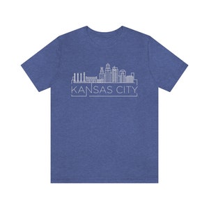May include: A blue t-shirt with a white outline of the Kansas City skyline and the text "KANSAS CITY" underneath.