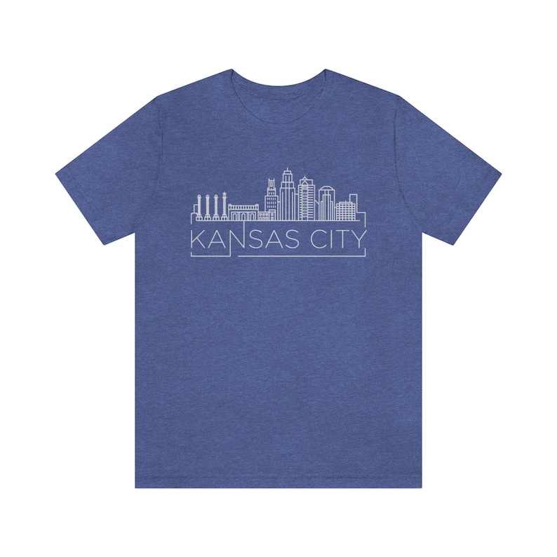 May include: A blue t-shirt with a white outline of the Kansas City skyline and the text "KANSAS CITY" underneath.