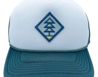 May include: A light blue trucker hat with a green mesh back. The front of the hat features a diamond-shaped patch with an embroidered green, yellow, and blue tree design.
