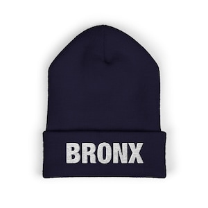 Puede incluir: Un gorro azul marino con un "BRONX" bordado en blanco en la parte delantera.
