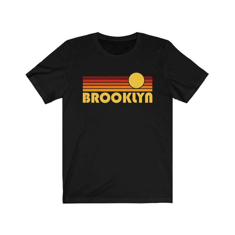 May include: Black t-shirt with a retro sunset graphic and the word "BROOKLYN" in yellow letters.