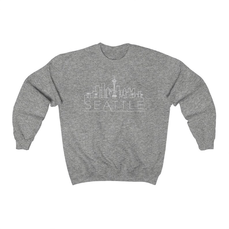 May include: A heather grey sweatshirt with a white outline of the Seattle skyline and the word "SEATTLE" underneath.