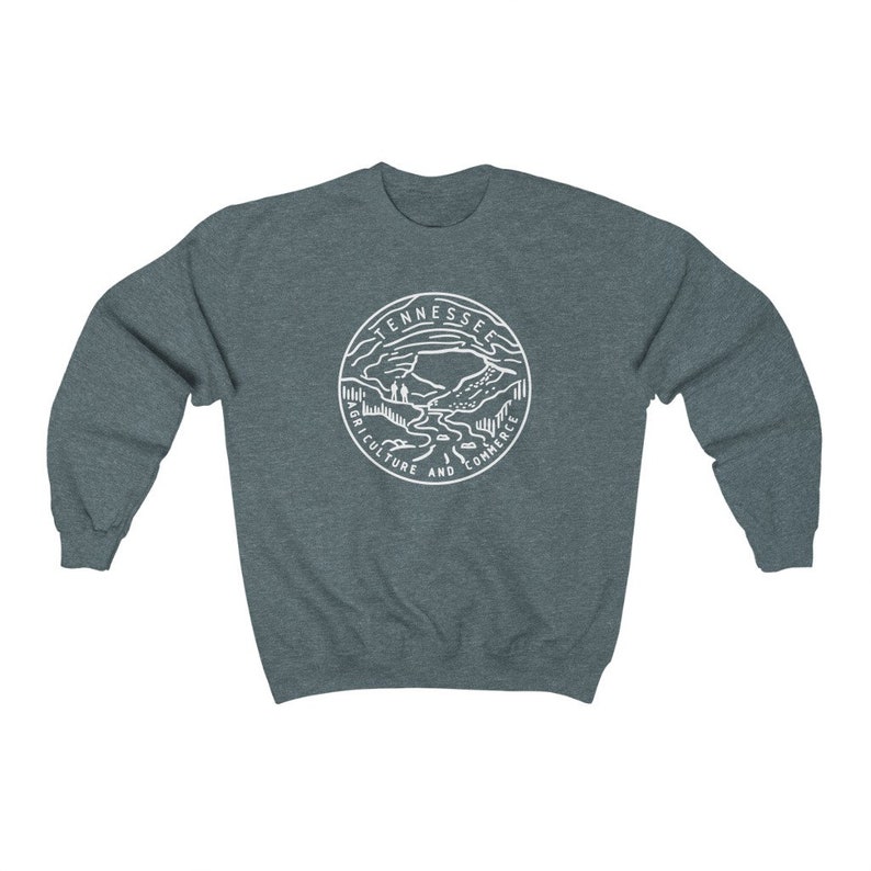 May include: A dark heather gray sweatshirt with a white graphic of the state seal of Tennessee. The seal features a mountain range, a river, and the words "Agriculture and Commerce".