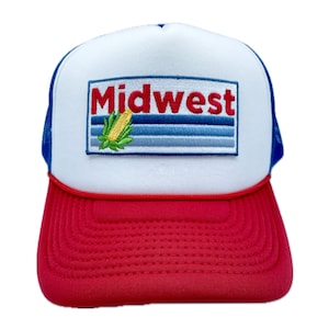 May include: A white and red trucker hat with a blue mesh back. The front of the hat features an embroidered patch with the word "Midwest" and a corn cob graphic.