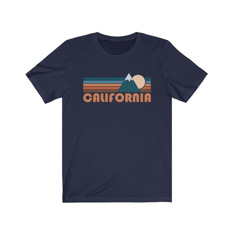 May include: A navy blue t-shirt with a retro-style graphic of a mountain range, sun, and the word "CALIFORNIA" in orange.