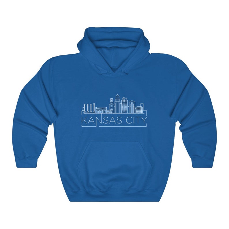 Może przedstawiać: Kr&oacute;lewska niebieska bluza z kapturem z białym rysunkiem linii horyzontu Kansas City. Tekst "KANSAS CITY" jest wydrukowany poniżej w kroju bezszeryfowym. Bluza ma przednią kieszeń i kaptur ze sznurkiem.