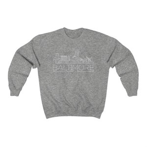 May include: A heather grey sweatshirt with a white outline of the Baltimore skyline and the word "BALTIMORE" underneath.