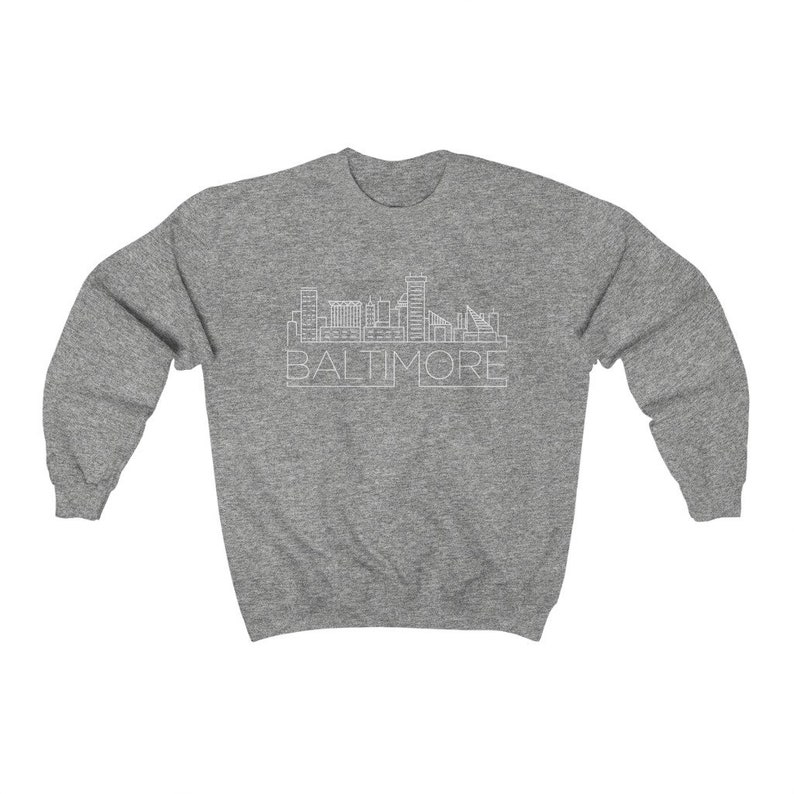 May include: A heather grey sweatshirt with a white outline of the Baltimore skyline and the word "BALTIMORE" underneath.