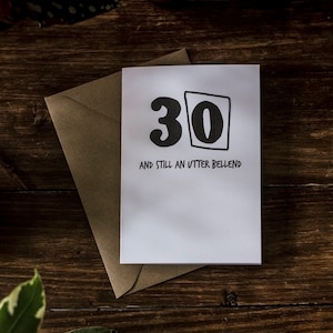 Op de afbeelding: Een witte kaart met zwarte tekst en een zwart nummer "30" in een vak. De tekst luidt "And still an utter bellend".