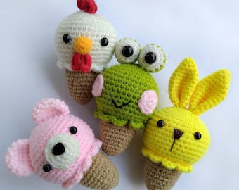 May include: Four crocheted stuffed animals shaped like ice cream cones. The ice cream is a chicken, a frog, a bunny, and a bear. The cones are all brown.