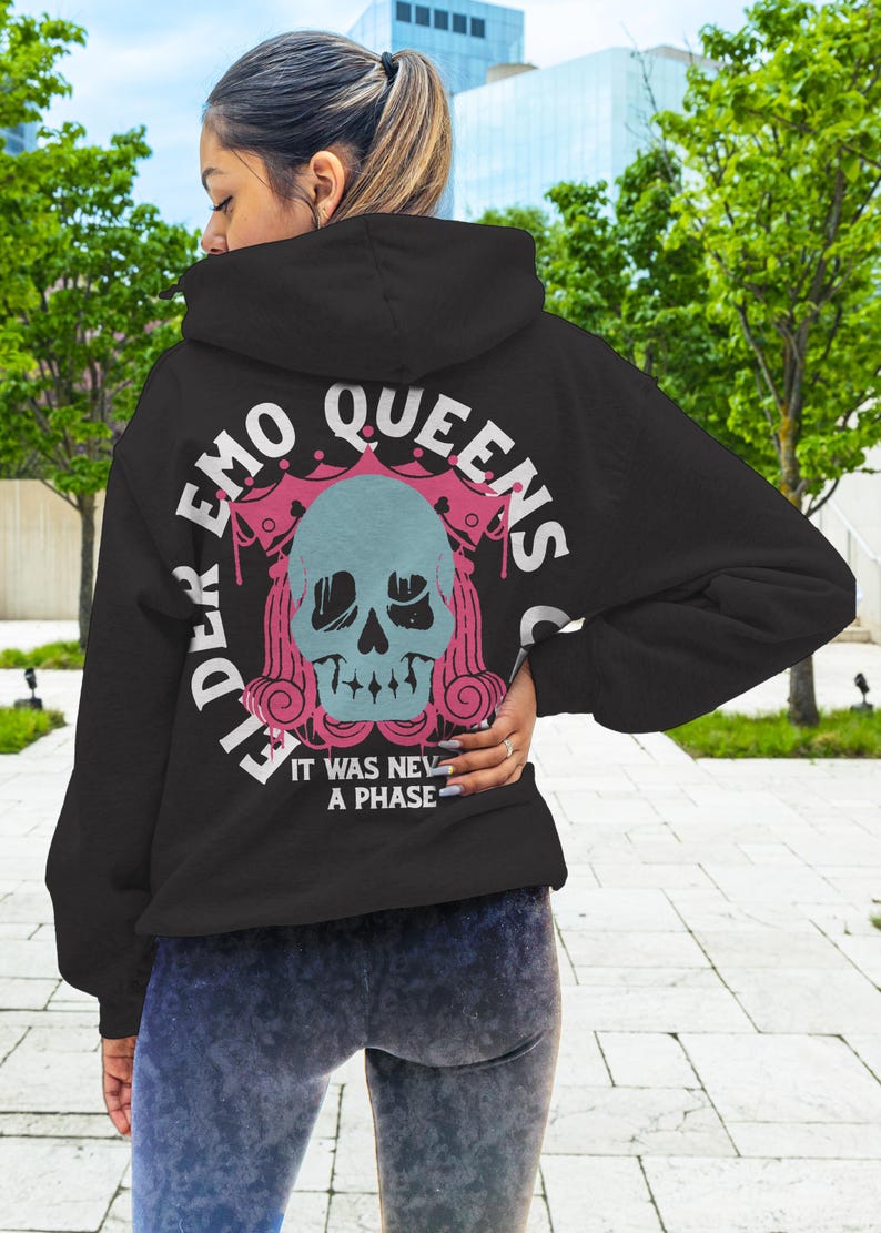 Pu&ograve; includere: Felpa nera con una stampa grafica rosa e bianca di uno scheletro con una corona e il testo "Elder Emo Queens Club" e "It was never a phase".