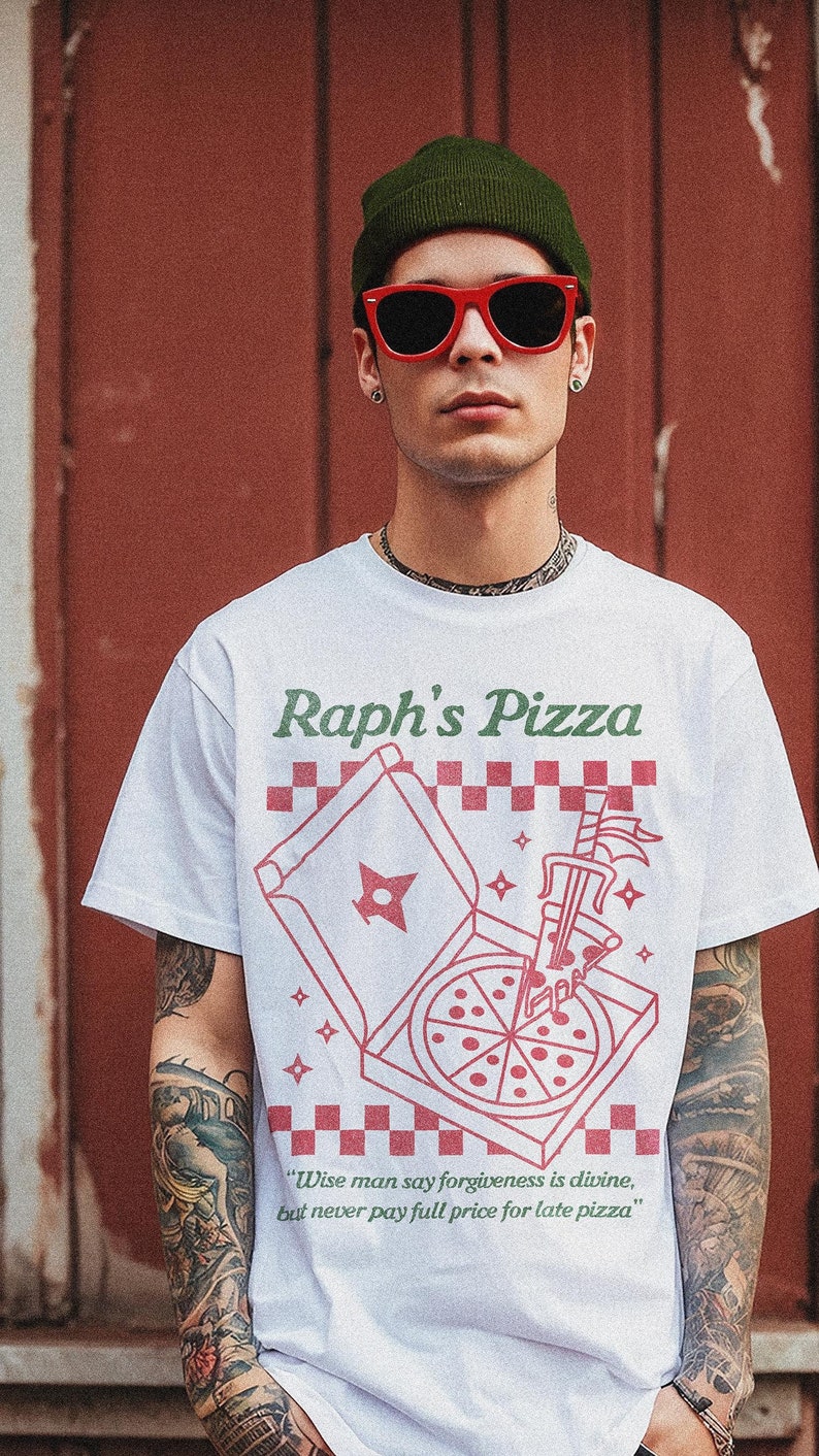 May include: A white t-shirt with a green and red graphic of a pizza box with a pizza inside. The text "Raph's Pizza" is printed in green above the graphic. The text "Wise man say forgiveness is divine, but never pay full price for late pizza" is printed in green below the graphic.