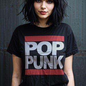 May include: Black t-shirt with the words "POP PUNK" in large white letters, framed by a red and white rectangle. The person in the image has black hair and is wearing the shirt.