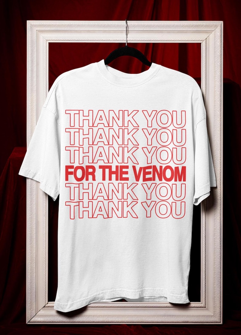 May include: White t-shirt with red text that reads 'Thank You Thank You Thank You For The Venom Thank You Thank You'.