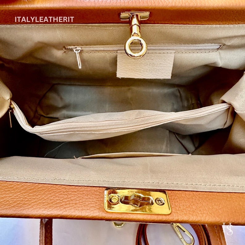 Puede incluir: El interior de una bolsa de m&eacute;dico de cuero marr&oacute;n con un cierre de broche dorado y un bolsillo con cremallera. La bolsa est&aacute; forrada con un tejido beige.