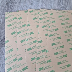 May include: Multiple sheets of brown adhesive tape with the text "3M 467MP 200MP Adhesive" and "3M WE" printed in green.