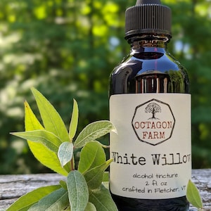 May include: A dark glass bottle with a black dropper lid, labeled "White Willow" alcohol tincture, 2 fl oz, crafted in Fletcher, VT. The bottle is sitting on a wooden surface with green leaves.