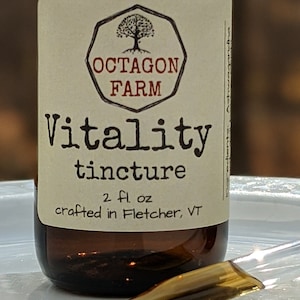Puede incluir: Una botella de vidrio marr&oacute;n con una etiqueta que dice "Octagon Farm Vitality tincture 2 fl oz crafted in Fletcher, VT".