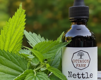 May include: A dark glass bottle of Octagon Farm Nettle tincture with a black dropper. The label reads "Nettle alcohol tincture 2 fl oz crafted in Fletcher, VT." Fresh green nettle leaves are in the foreground.