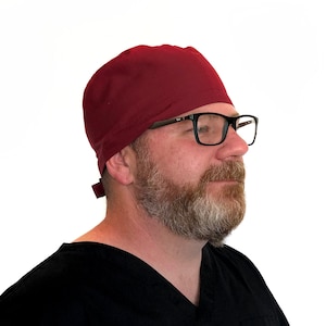 May include: A burgundy scrub cap with a tie at the back. The cap is made of a soft, comfortable fabric and is perfect for medical professionals.