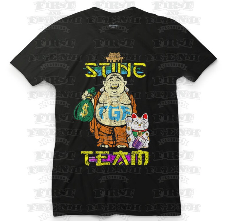 May include: Black t-shirt with a graphic of a cartoon Buddha holding a bag of money and a lucky cat. The text "STING PG" and "T-TEAM" are printed on the shirt.