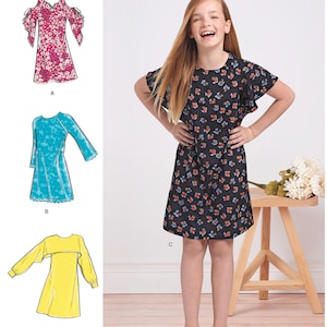 May include: Simplicity pattern 8567 for girls' plus sizes. The image shows a girl wearing a black dress with a floral pattern. The pattern includes designs for dresses in pink, turquoise, and yellow. The Simplicity logo is at the top.