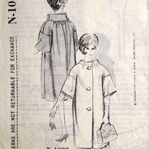 May include: Vintage sewing pattern featuring a coat design. The illustration shows a woman in a knee-length coat with three buttons and short sleeves. The pattern is labeled N-1083 and includes the text "Patterns are not returnable for exchange."