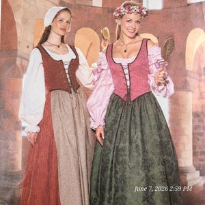 Op de afbeelding: Twee vloerlange jurken met vetersluiting en lange mouwen. De linkerjurk heeft een witte blouse, een roestkleurig lijfje en een beige rok. De rechterjurk heeft een roze blouse, een roze lijfje en een donkergroene rok met een patroon.