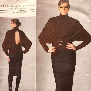 Pode incluir: Um top marrom de manga comprida com gola alta e uma abertura em forma de fechadura nas costas. O top é usado com um cinto marrom e uma saia marrom. O texto "DONNA KARAN COLLECTION" e "OGUE* PATTERNS AMERICAN DESIGNER" é visível na imagem.