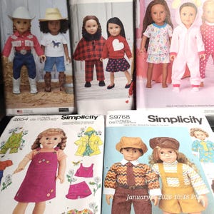 May include: A collection of doll clothing patterns and dolls. The dolls are dressed in various outfits, including a cowboy-themed ensemble, a red plaid outfit, and pajamas. The patterns are from Simplicity.