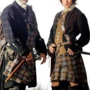 May include: Two men in traditional Scottish attire. One man wears a dark coat over a plaid kilt, holding a wooden staff. The other man wears a brown coat and vest over a plaid kilt, with a sword at his side. Both wear knee-high socks and boots.