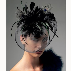 May include: A black headpiece with a veil, adorned with feathers and peacock accents. The headpiece features a net veil that covers the face. The feathers are black and green, with a few peacock feathers with blue and green details.