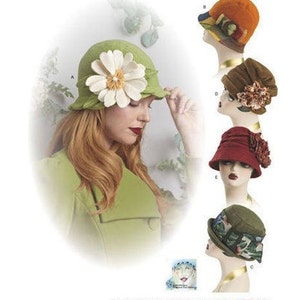May include: Five different felt hats with various embellishments. The hats are displayed on mannequins with different hairstyles. The hats are in various colors, including green, orange, brown, red, and green.