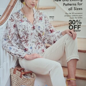 May include: A woman wearing a floral print blouse and cream-colored pants sits on wooden stairs. The image is from a McCall's pattern book, with text that reads "Over 30 New and Exciting Patterns for all Sizes" and "30% OFF MSRP". A straw basket sits nearby.