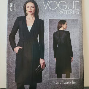 Op de afbeelding: Vogue Patterns naaipatroon voor een zwarte wikkeljas met een riem. Het patroon is ontworpen door Guy Laroche. Het patroonnummer is V1709.