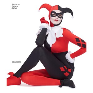 May include: A woman wearing a red and black jester costume with a white collar and diamond pattern. She is wearing a black mask with a white eye mask. The costume is a Simplicity Pattern 8434.