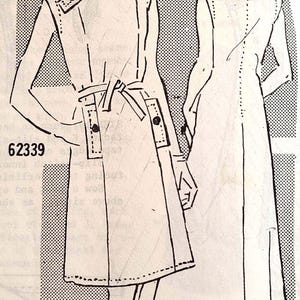 May include: Vintage sewing pattern illustration featuring a woman's coat design. The line drawing shows a belted coat with shoulder details and button accents. The pattern number is 62339, with the name "Biki" and the month "January" visible.