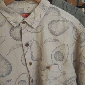 May include: A white button-down shirt with a black and white avocado print. The shirt has a pocket on the left side.