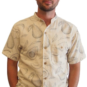 May include: A beige short-sleeved button-up shirt with a mandarin collar and a pattern of black and white avocado drawings.