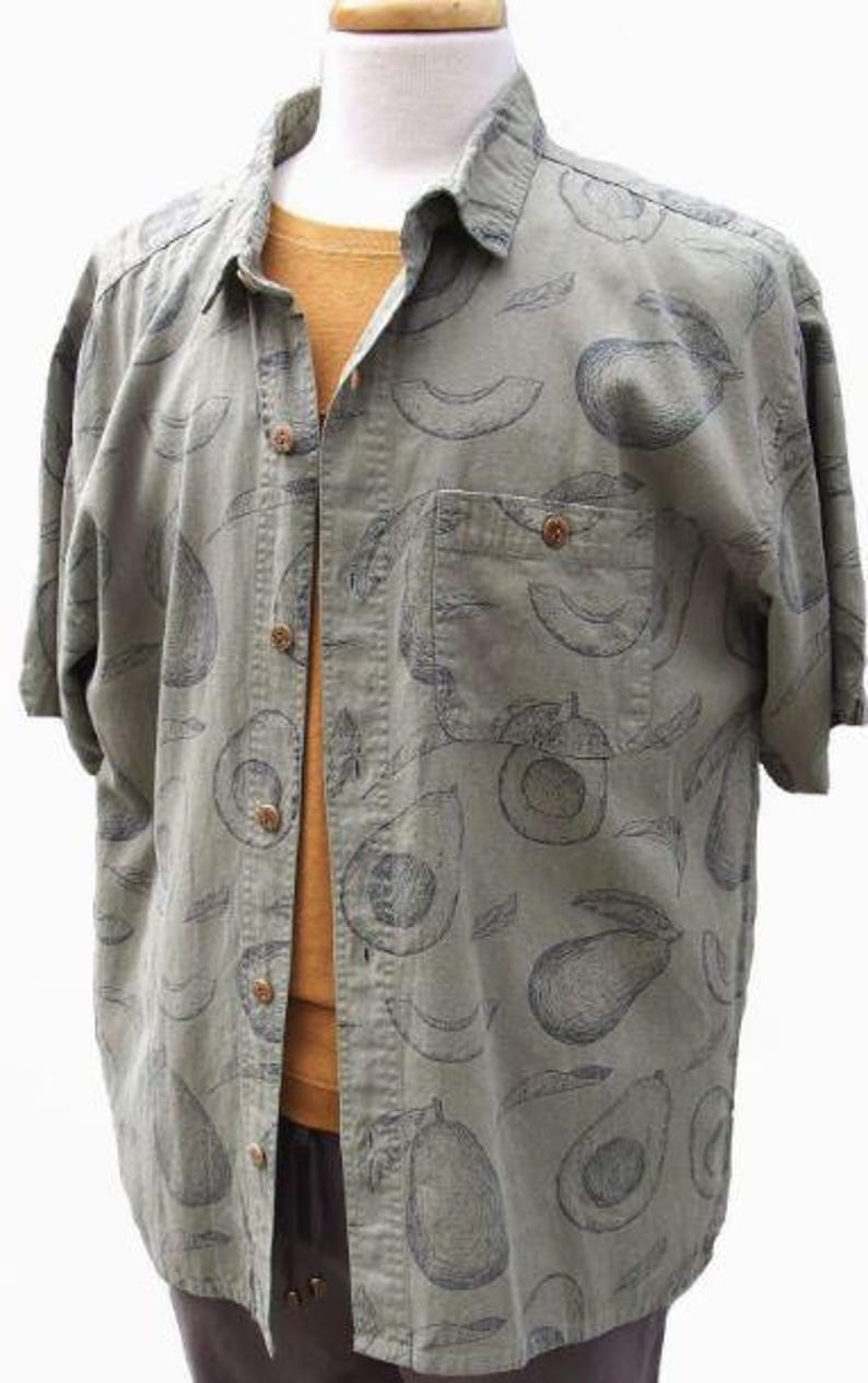 May include: A green short-sleeved button-down shirt with a pattern of black avocado illustrations.