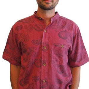 May include: A red short-sleeved button-down shirt with a black fig print. The shirt has a mandarin collar and a chest pocket.
