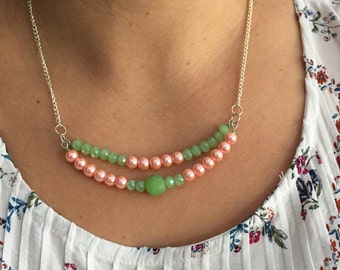 Glamorous pink pearl and green crystal necklace with silver-colored chain.