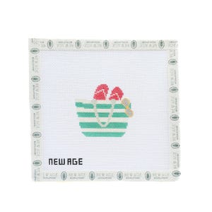 May include: Needlepoint canvas featuring a beach bag design with red flip-flops and a yellow beach accessory. The bag has horizontal stripes in turquoise and white. The text "NEW AGE" is displayed at the bottom of the canvas.