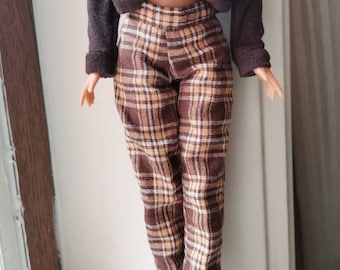 Könnte beinhalten: Braune und beige karierte Hose mit breitem Bund.