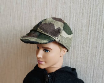 Puede incluir: Una gorra de béisbol con estampado de camuflaje y visera curva. La gorra está hecha de un tejido suave y texturizado.