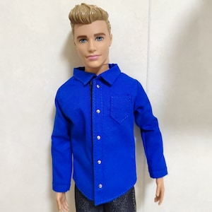 May include: A blue long-sleeved shirt with a button-up front and a pocket on the left chest.