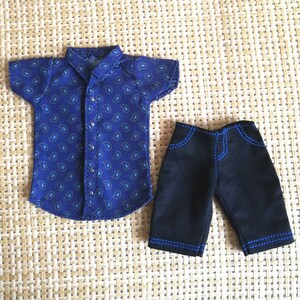 May include: A blue paisley patterned short-sleeved shirt and black denim shorts with blue stitching.