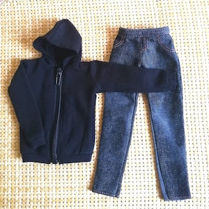 May include: A black hooded sweatshirt with a zipper closure and a pair of blue denim jeans.