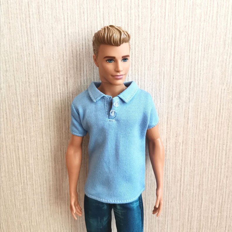 May include: A light blue polo shirt with a button-up collar and short sleeves. The shirt is made of a soft, textured fabric.