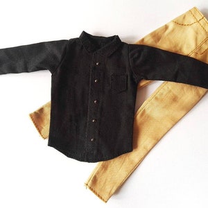 May include: A black long-sleeved shirt with a button-up front and a brown pair of pants.